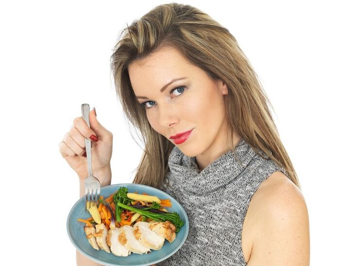 Mädchen, das Huhn mit Gemüse isst, um Gewicht zu verlieren